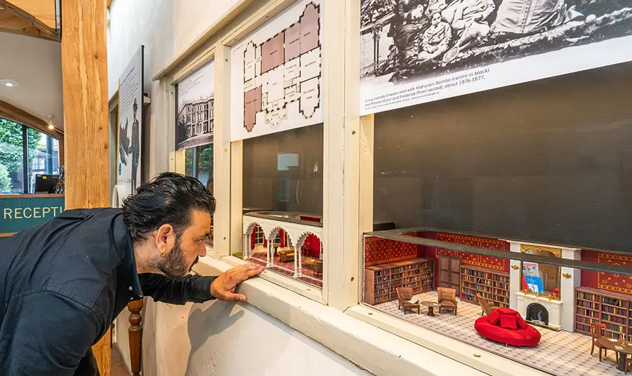 A person looking at a model of a library in a museum display