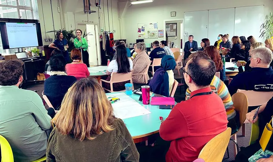 Groups of people sitting at tables watching a presentation