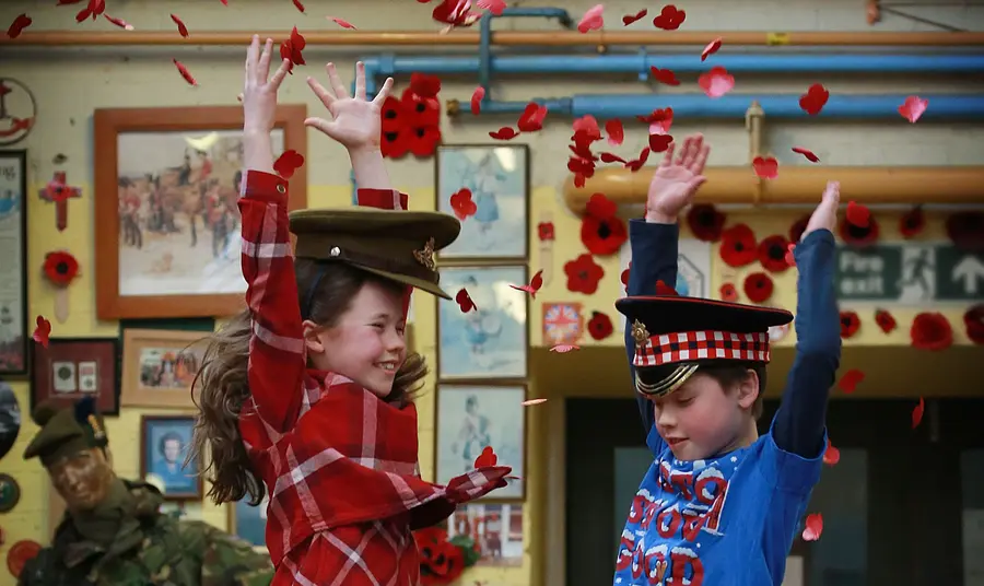 Children jumping and throwing poppies