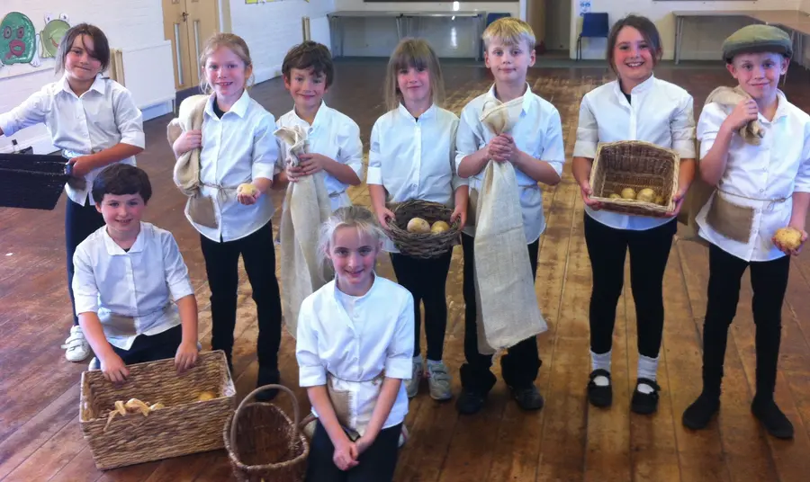 Local schoolchildren hold period items