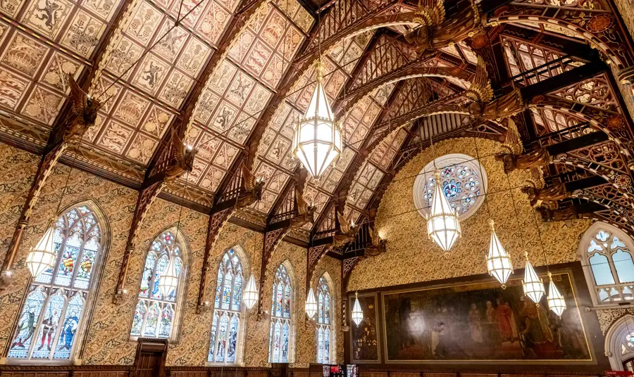 The interior of the Great Hall at Rochdale Town Hall, with decorative ceiling panels and gold angel statues held by wooden beams.