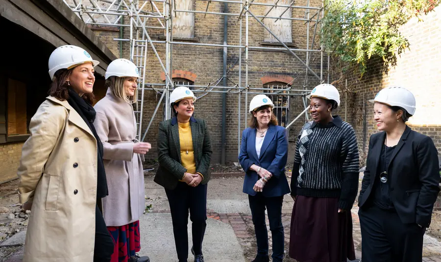 Group of people wearing hard hats in a courtyard of historic building, Alice Billings House in Stratford