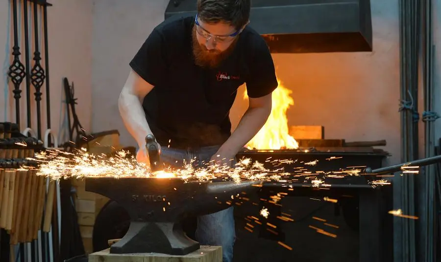 A blacksmith striking metal, with sparks flying