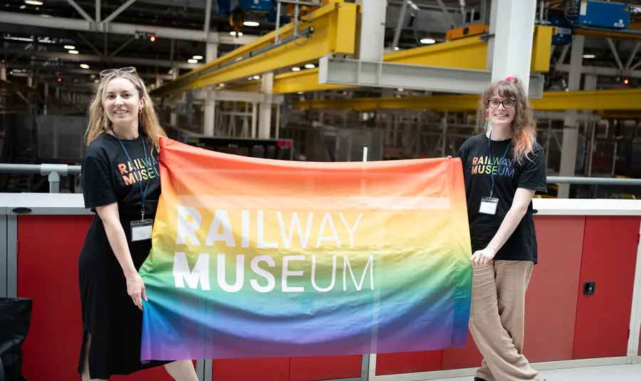 Two people holding a Pride flag