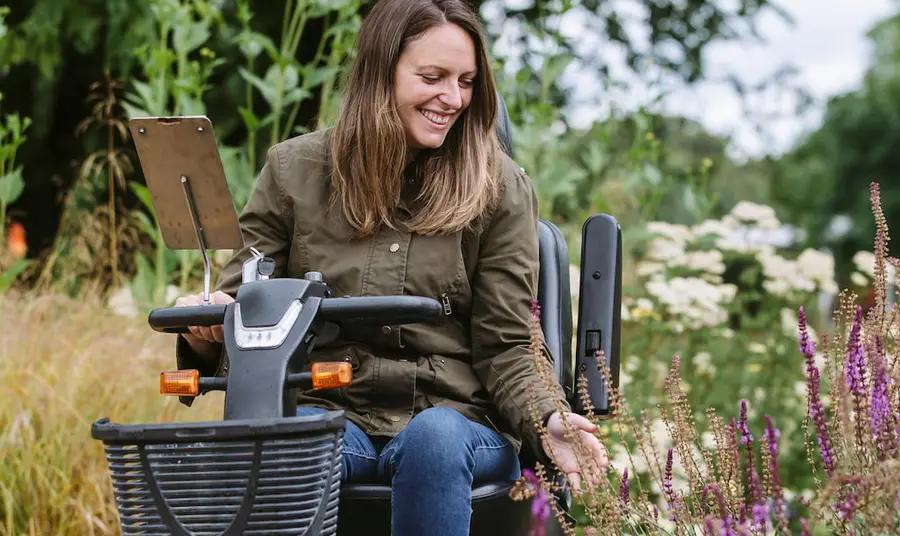 3)	A visitor using a mobility scooter in the Wellbeing Garden at RHS Garden Wisley