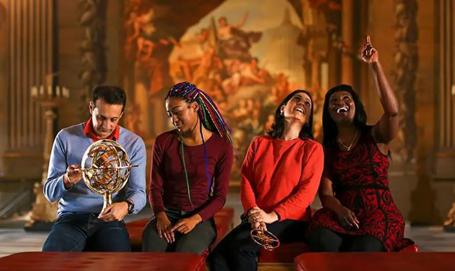 Four people sitting with large artwork behind them