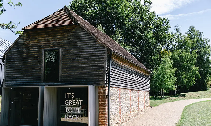 Exterior of Ditchling Museum with sign saying 'it's good to be back'.