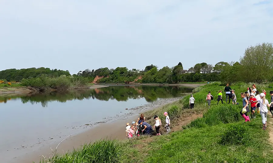 Children taking part in activities by the river edge