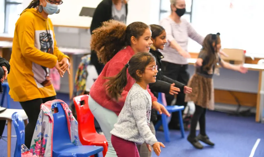 Children and adults dancing and smiling