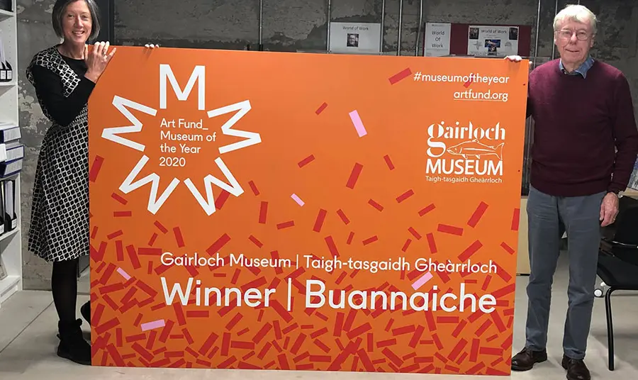Gairloch Museum staff holding a Museum of the Year banner