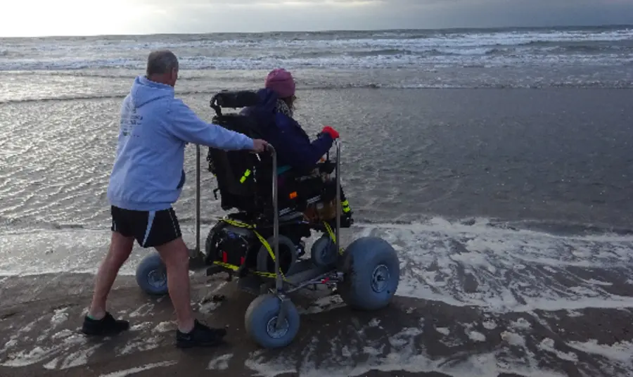 All-ability access to Garnock Landscape Man pushing person using large wheelchair next to river