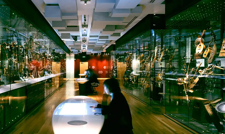 People sitting at tables with modern displays of musical instruments
