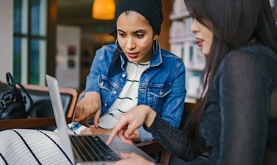 Two people look at laptop