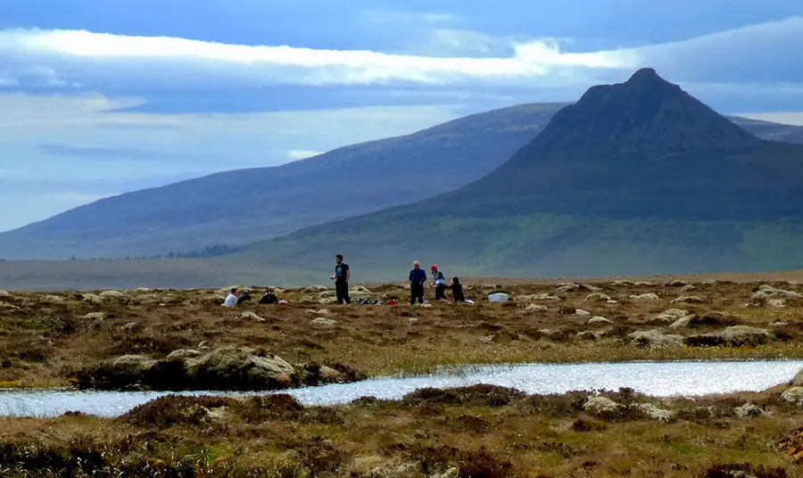 People in natural landscape with mountain in distance