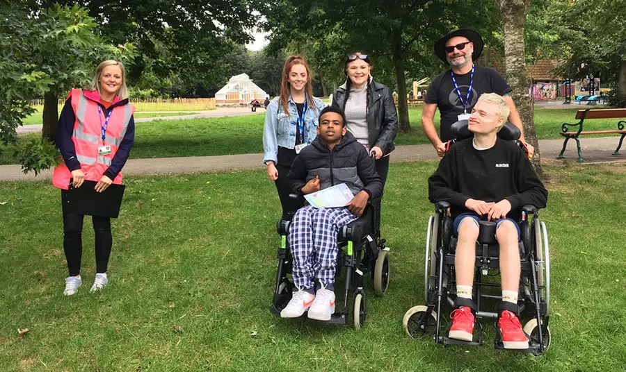 Six people outside. Two people are wheelchair users. 
