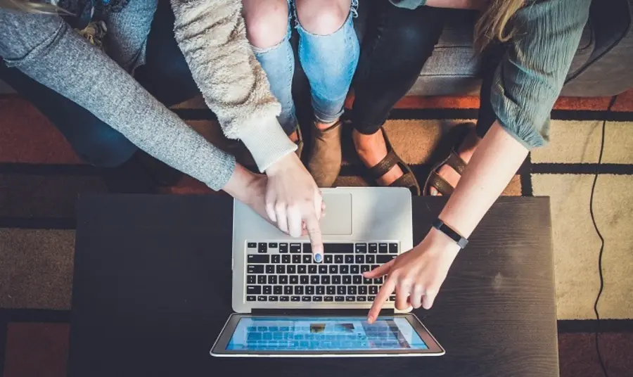 Digital guidance for projects Three people point at a laptop