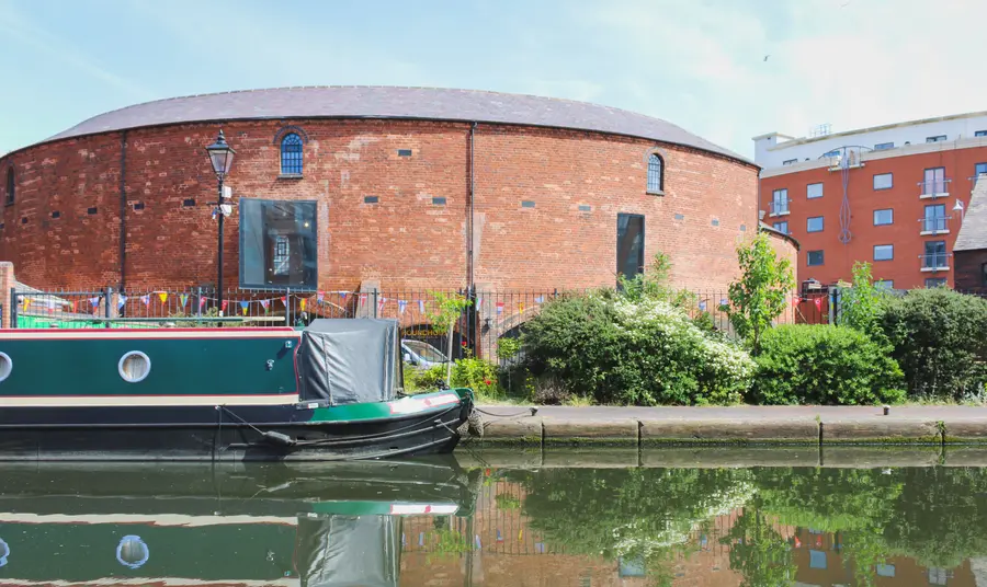 Round building with canal in foreground