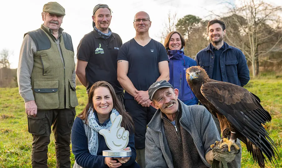 Group of people holding award and an eagle
