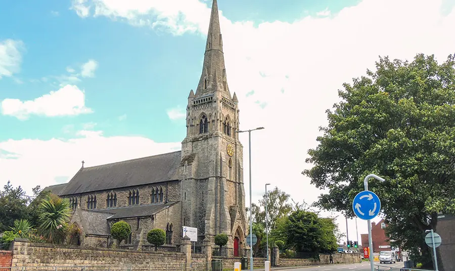 A stone church with a spire, in a town