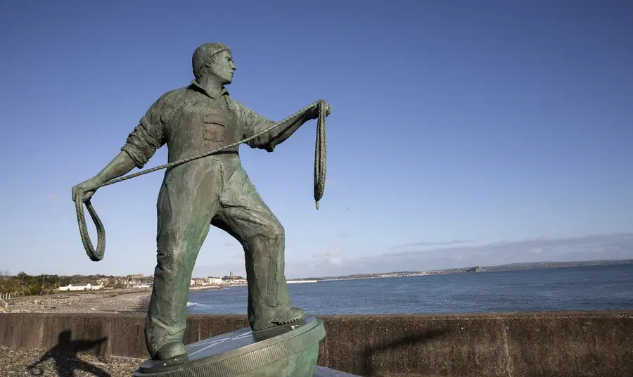 Sculpture of a fisherman holding a rope and looking out to sea