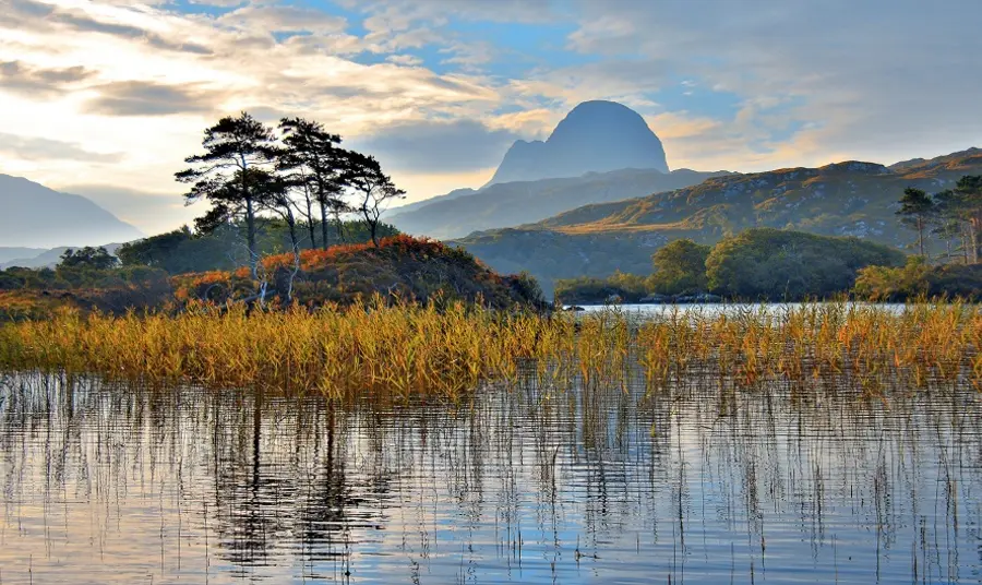 Nature and landscapes guidance Landscape vista with water in foreground, an island in the middle of the water, and mountains in the background