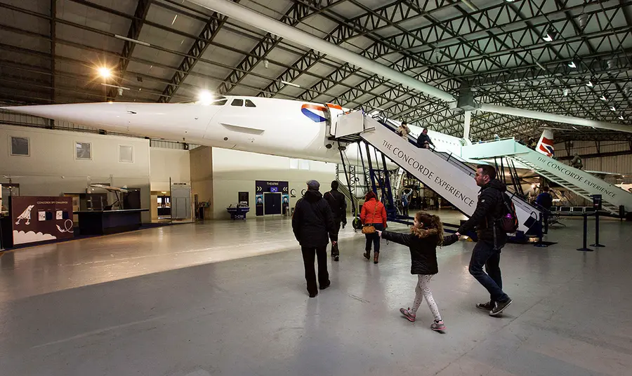 People approaching aeroplane in hangar 