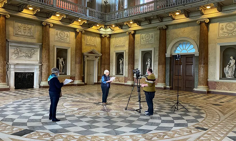 Digital skills help volunteers spread the word about Wentworth Woodhouse Three people recording film in large stately room