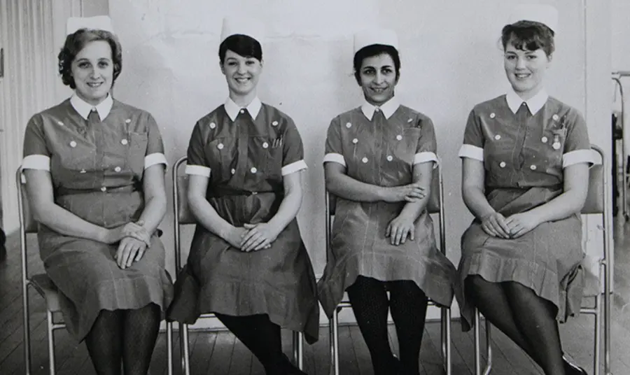 A black and white photograph of four nurses in uniform.