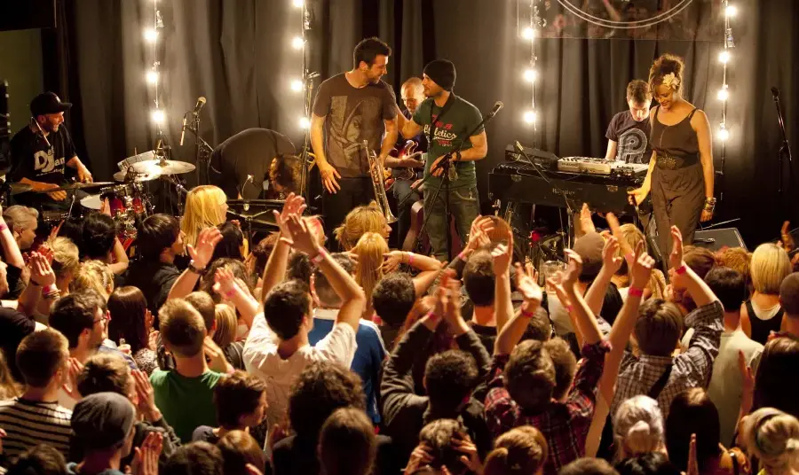 A band performing on a stage in front of a large crowd