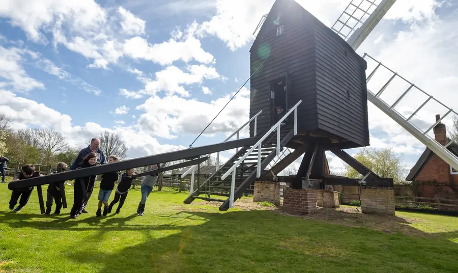 A group of people including children turn Bourn Windmill