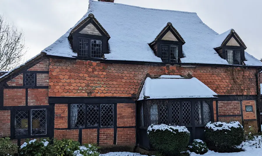 A timber-framed building covered in snow