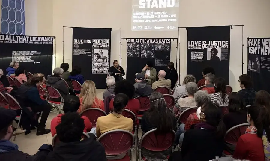 A photo of an indoor event, with a speaker talking to a seated audience