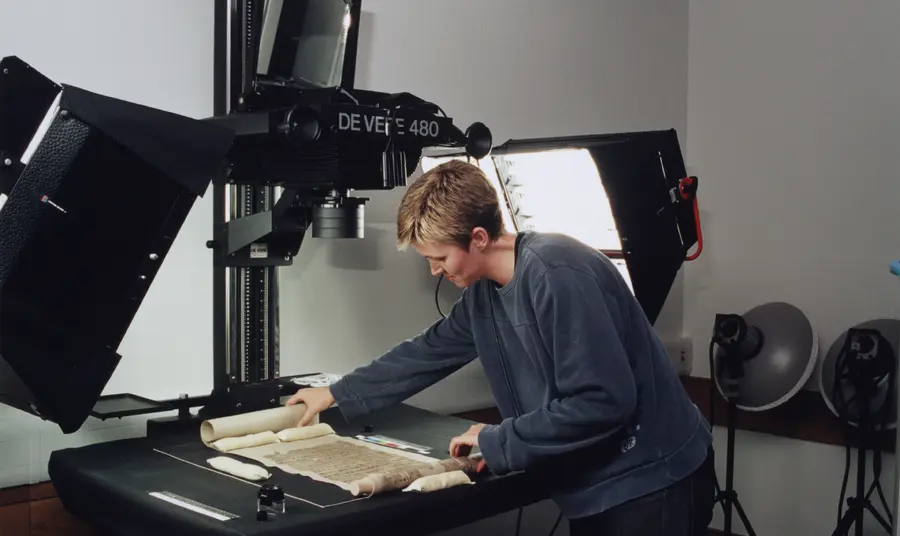 A woman placing a manuscript under a professional digitisation device