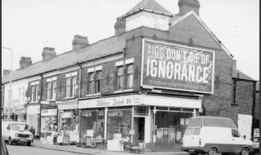 Old photo showing large billboard with the words "AIDS: don't die of ignorance"