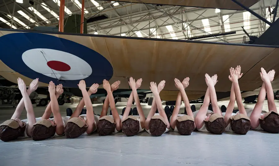 Children performing under the wing of an old RAF aeroplane