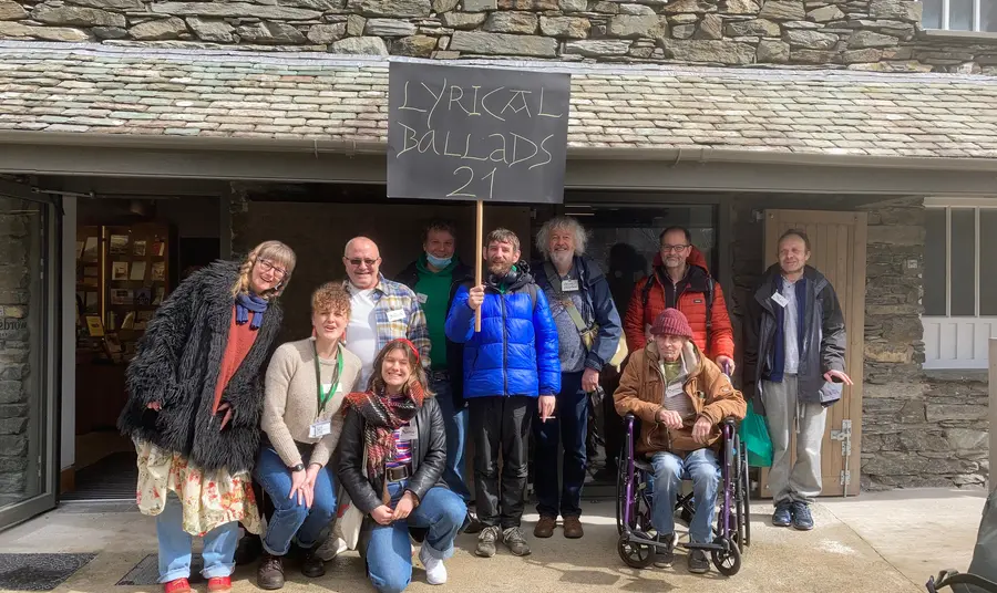 A group of people standing in front of Wordsworth Museum. One of them is holding a sign that reads 'Lyrical Ballads 21' 