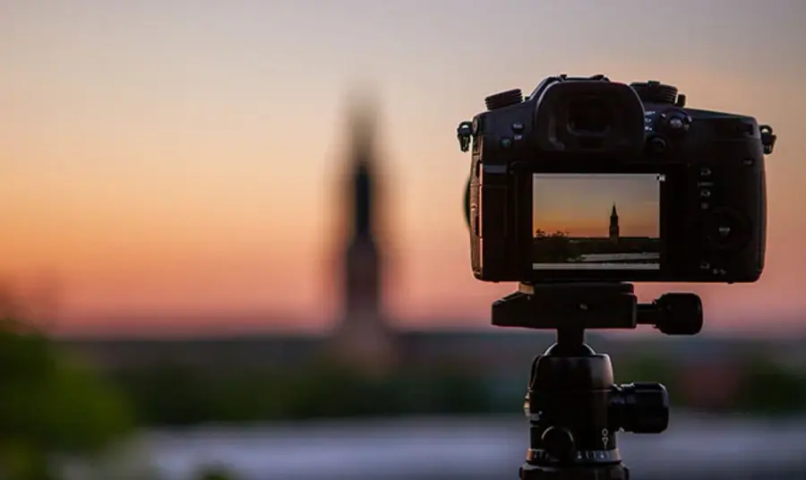 A close-up of a camera showing the digital preview screen, and in the distance, the landmark that's being photographed