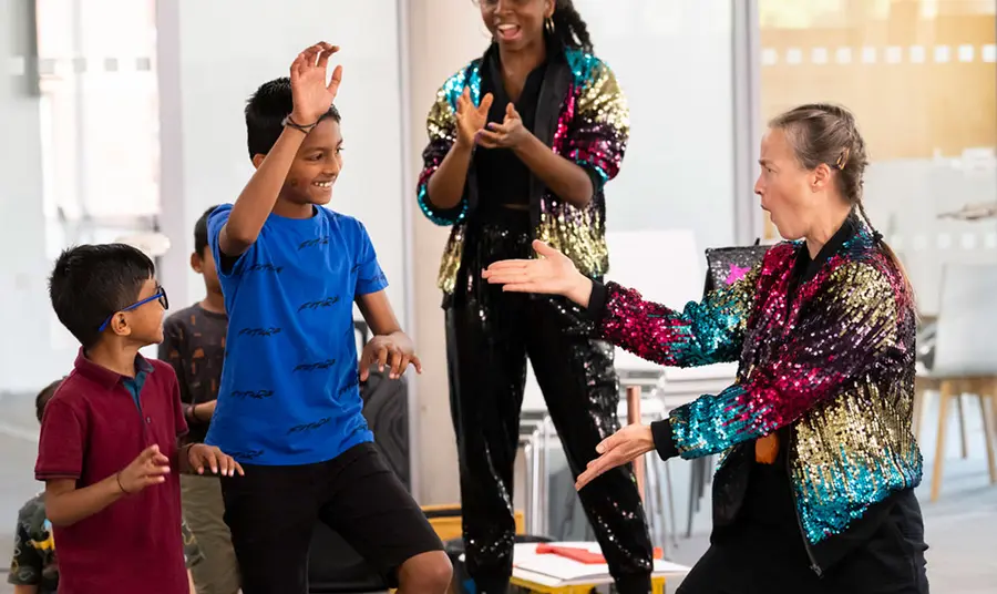 Two young boys taking part in a performance with two women. Photo credit:  Andrew Baker.