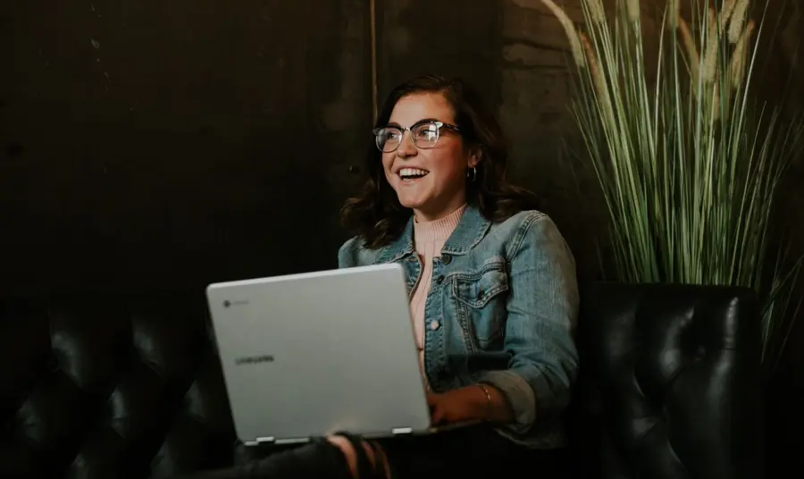 Person smiling whilst using laptop
