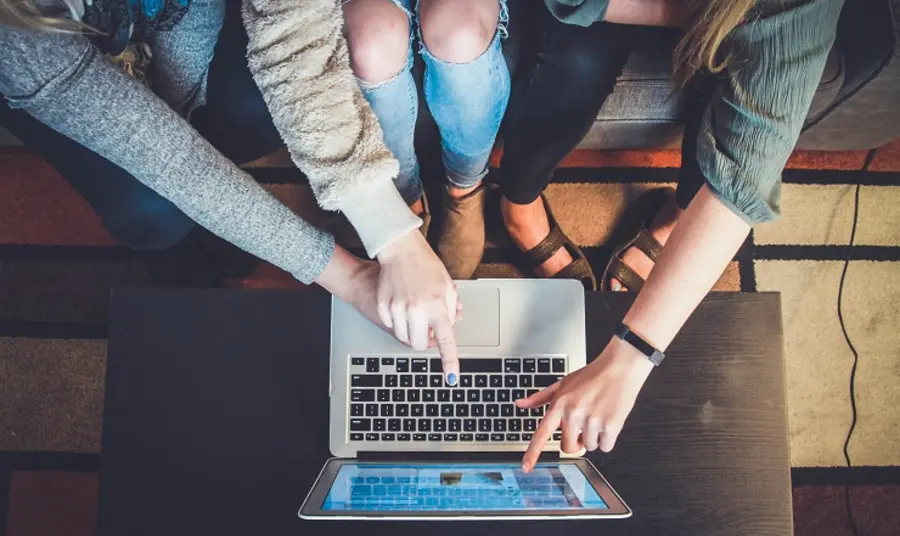 People pointing at a laptop
