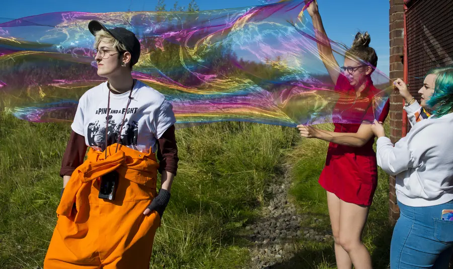 Photoshoot with giant bubbles and three people