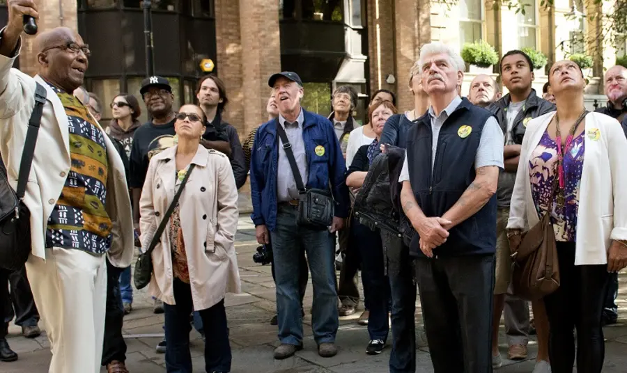 Understanding your heritage guidance A group of people listening to a person speaking whilst looking up