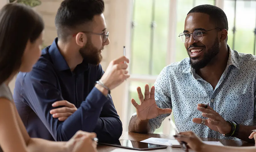 Three people sitting around a table discussing ideas