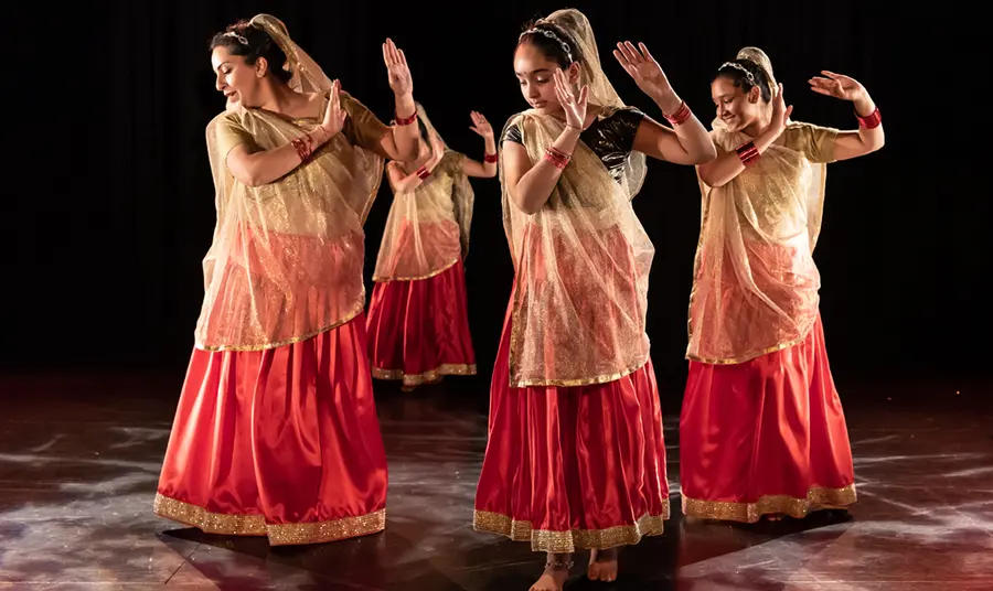 A group of women in traditional dress doing an Indian dance