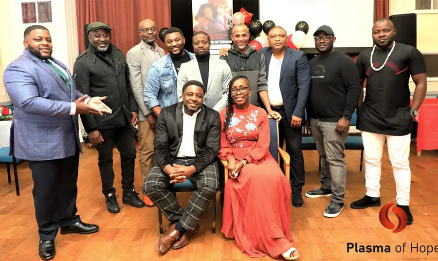 A group of black people pose for a photo including a woman