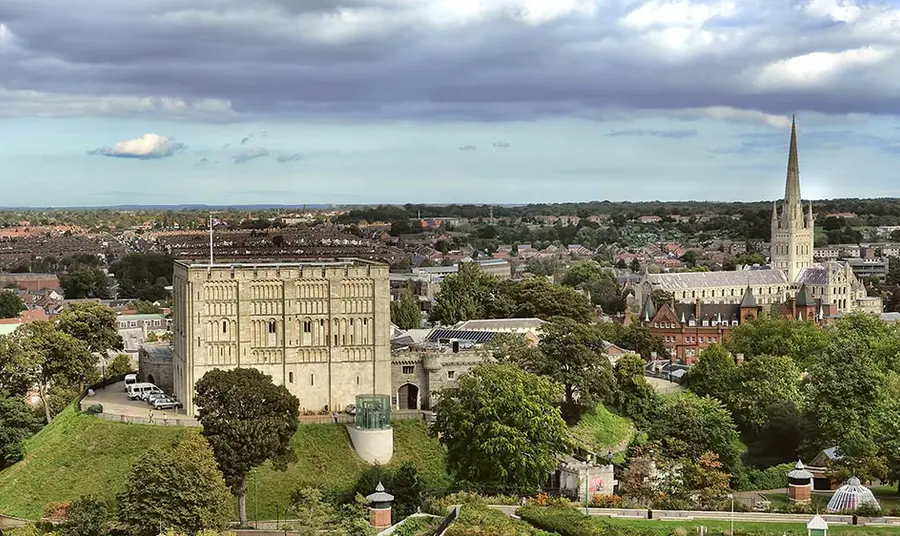 exterior view of a large norman castle in the middle of a city