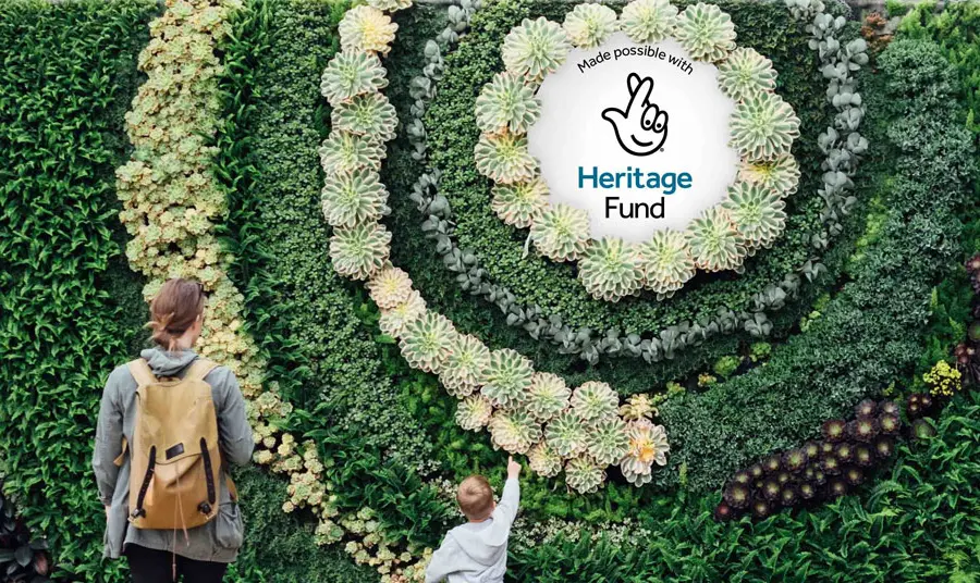 The National Lottery Heritage Fund acknowledgement stamp is displayed in the centre of a living plant wall