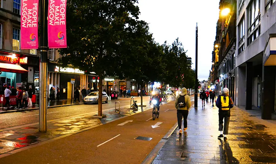 Sauchiehall Street The western end of Sauchiehall Street at dusk: on the right people are walking and cycling by a People Make Glasgow banner and on the left a group of people are standing outside a bar