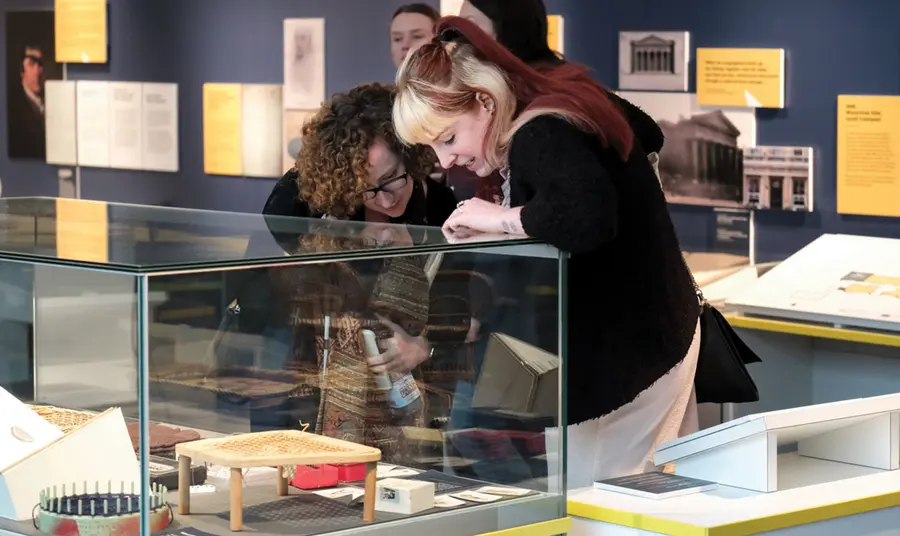 Two women looking into a glass museum display case.