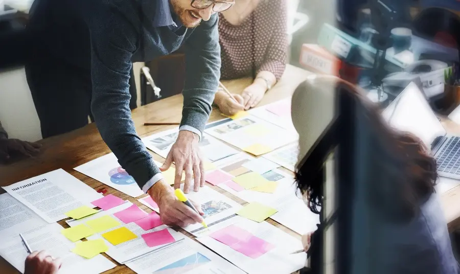 Investing in resilience People working on an office desk with bright sticky notes